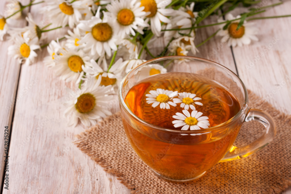 Herbal tea with fresh chamomile flowers on white wooden background Herbal tea with fresh chamomile flowers on white wooden background