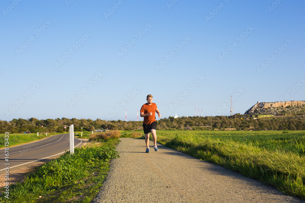 Fototapeta premium Athletic young man running in the nature. Healthy lifestyle.