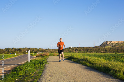 Athletic young man running in the nature. Healthy lifestyle.