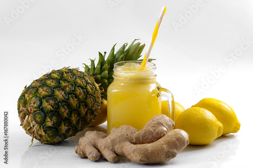 Juicing raw fruits and vegetables and juice extractor recipes concept with pineapple, lemon and ginger, the ingredients for a detox smoothie that helps with inflammation and digestion