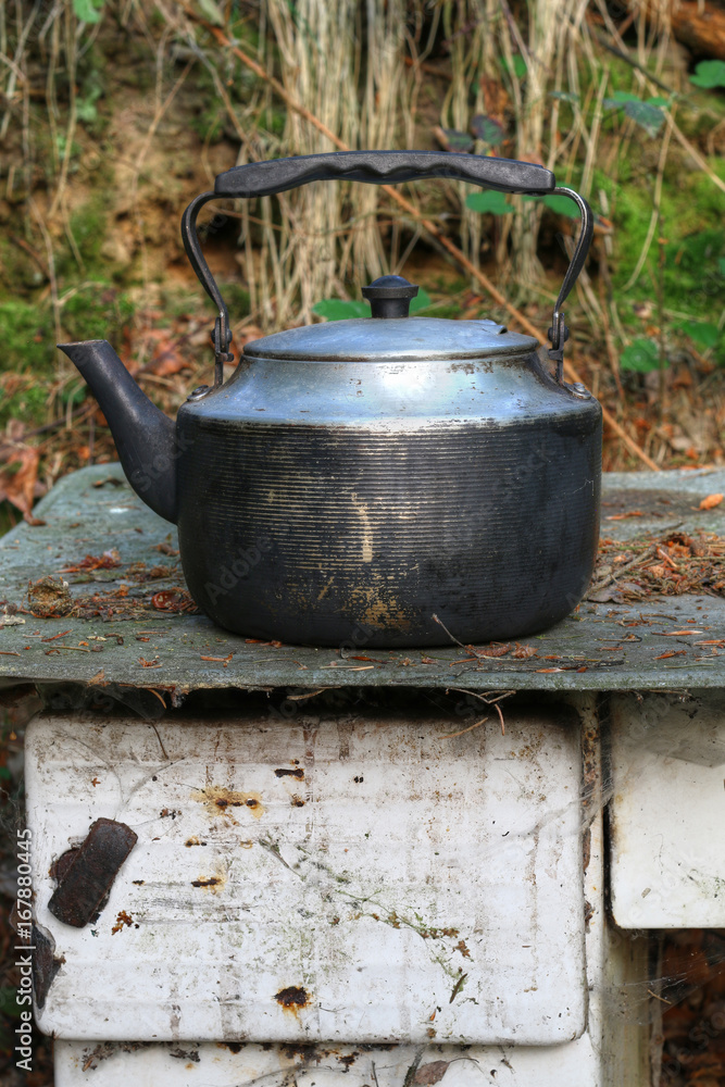 Worn teapot on old stove