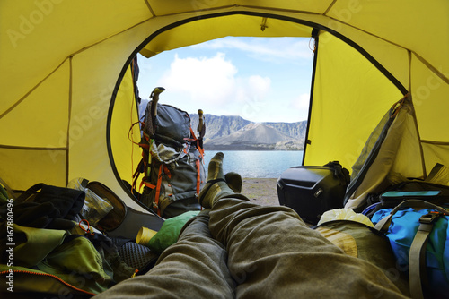 Traveler lying down in the tent with segara anak lake view photo