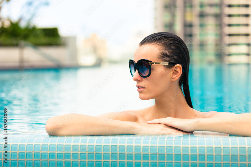 Attractive girl relaxing in swimming pool. 