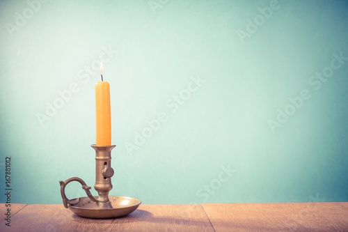 Fotografie Vintage old bronze candlestick with burning candle