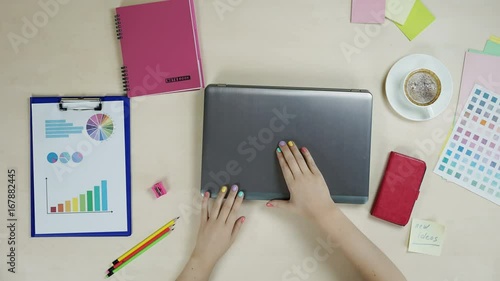 Female freelance designer working on laptop, stop motion, top view, creativity. Stop motion video of female hands working on laptop photo