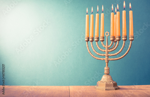 Hanukkah menorah with burning candles for holiday card background. Retro old style filtered photo