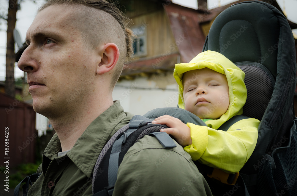 Travelling with a child. One year old child travelling in touristic baby carrier.