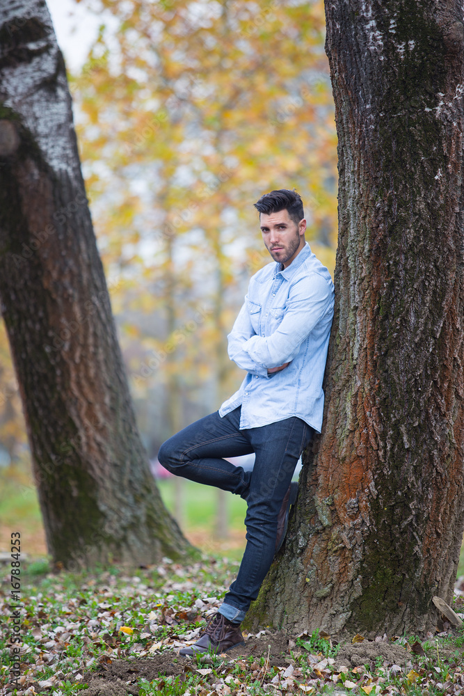 Handsome desolate man in the park. Autumn scenery