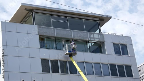 A man is cleaning windows on telescopic stage