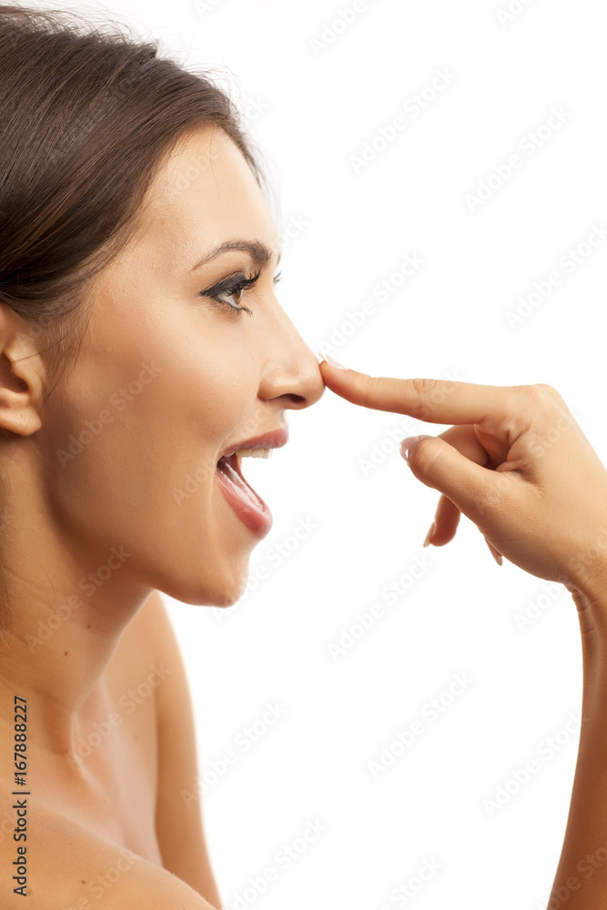 Beautiful smiling young woman touching her nose on white background Beautiful smiling young woman touching her nose on white background