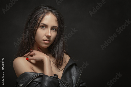 beautiful woman with bare shoulders looking at camera on black background