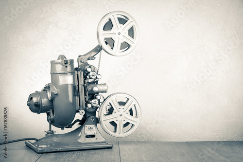 Retro old reel movie projector for cinema. Vintage style sepia photo