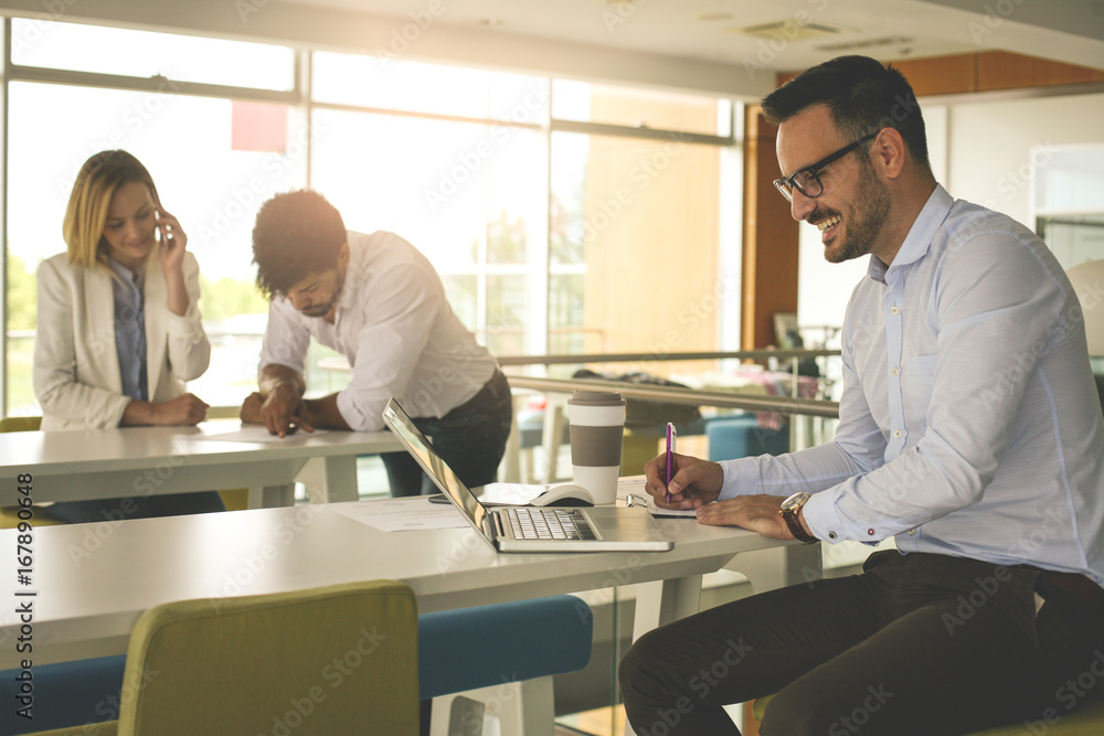 Fototapeta premium Business man working in office on laptop and writing document. Business people working in office.