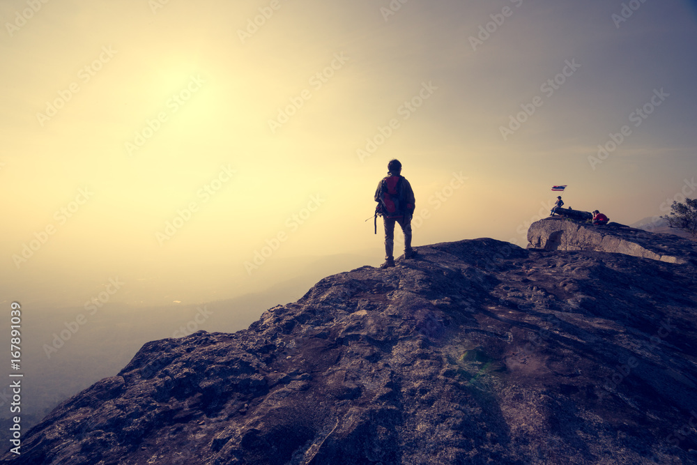 man standing on rock mountain with sunrise