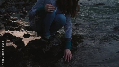 Young woman at sunset playing with water At the mountains photo