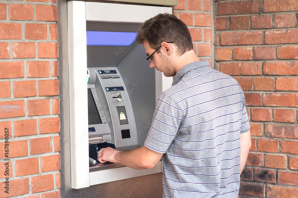 Obraz premium Man using ATM bank machine