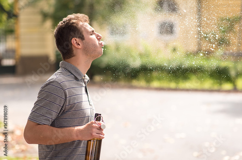 Young man spit out alcohol photo