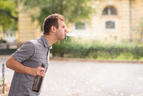 Young man spit out alcohol photo