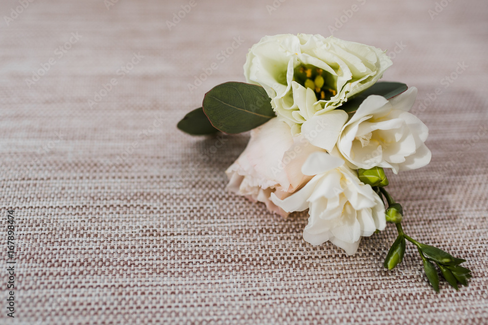Little white boutonniere lies on the chair Little white boutonniere lies on the chair