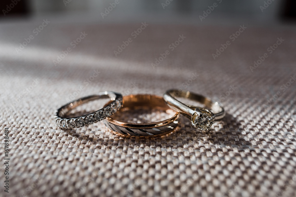 Golden wedding rings with sparkling stones lie on the chair Golden wedding rings with sparkling stones lie on the chair