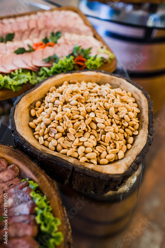 Wooden dish with salty peanuts