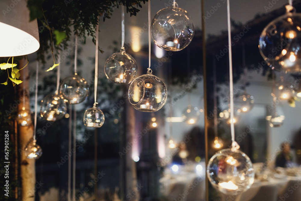 Glass balls with candles hang before the window Glass balls with candles hang before the window