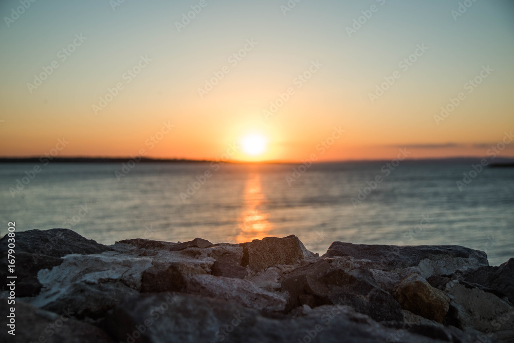 Coastal stones on sunset background
