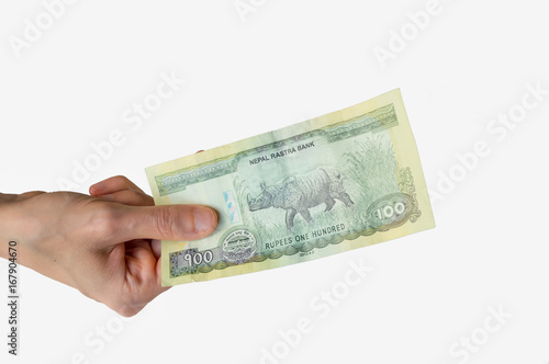 Woman holding a hundred Nepal Rupees note in her hand