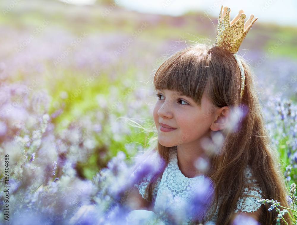 Princess child girl in crown on lavender field at summer day, happy childhood concept Princess child girl in crown on lavender field at summer day, happy childhood concept