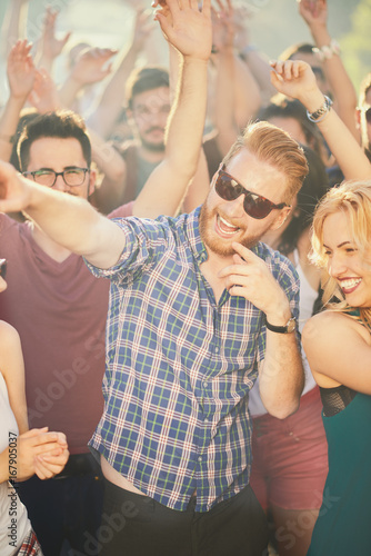 Crowd of people at music festival dancing and enjoying music