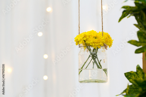 The marigold flowers in a glass bottle hanging. Flower vase arrangements on blurred background and bokeh © NVB Stocker