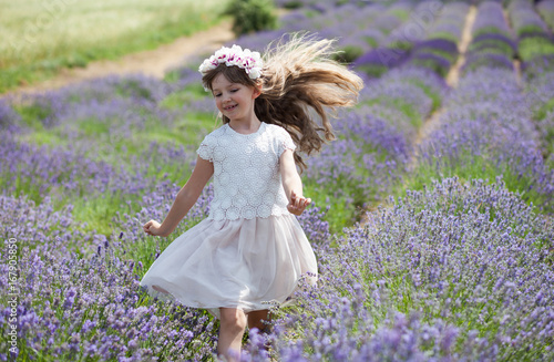 Child girl runs in lavender field, freedom concept