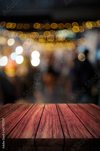 wooden table in front of abstract blurred background of lights