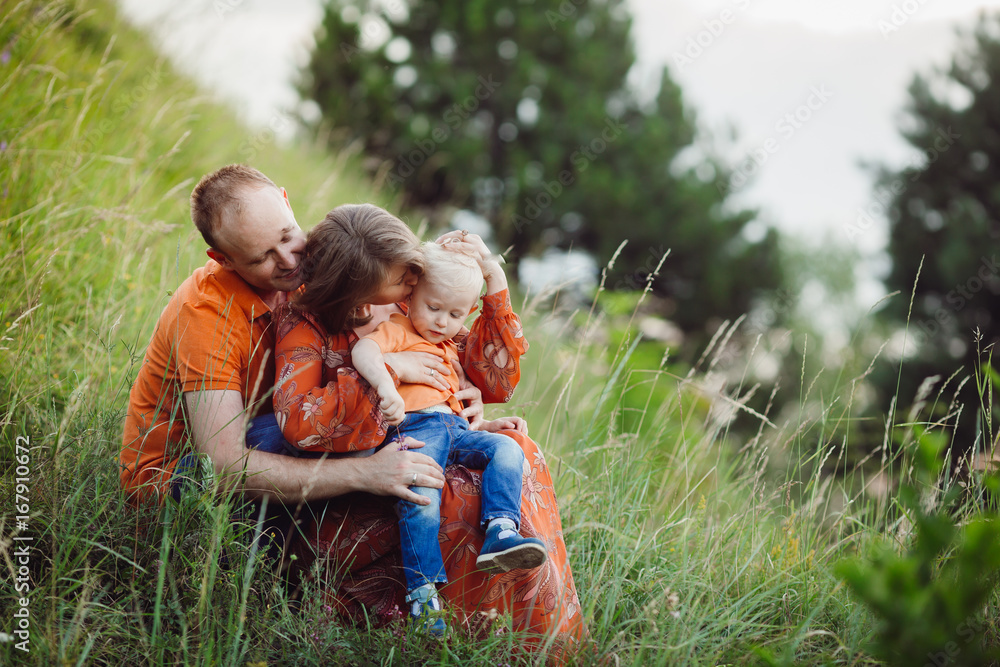 Family sits hugging on the lawn Family sits hugging on the lawn