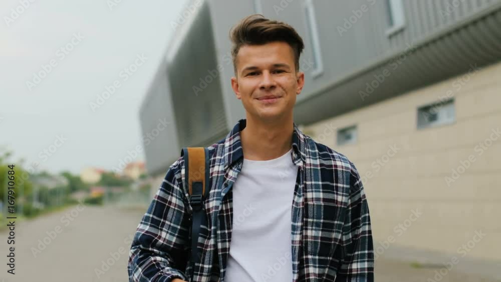 Close up shot of man with the backpack walking near the airport terminal and using smart phone.
