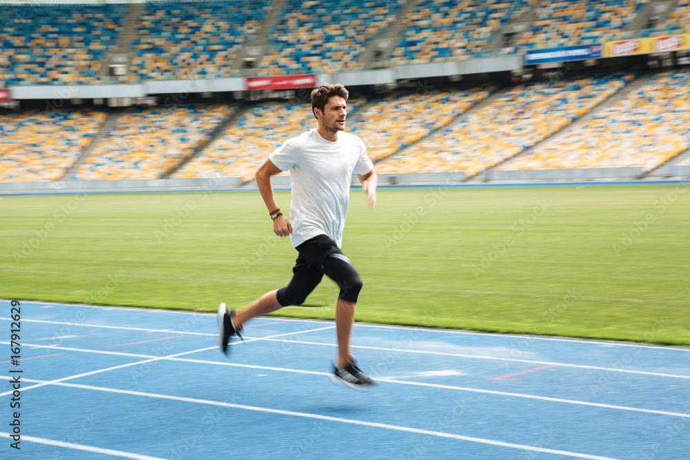 Fototapeta premium Side view of a young professional sprinter running