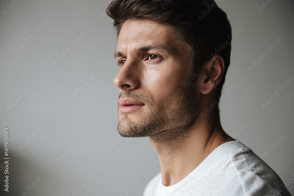 Fototapeta premium Young sports man standing near grey wall outdoors