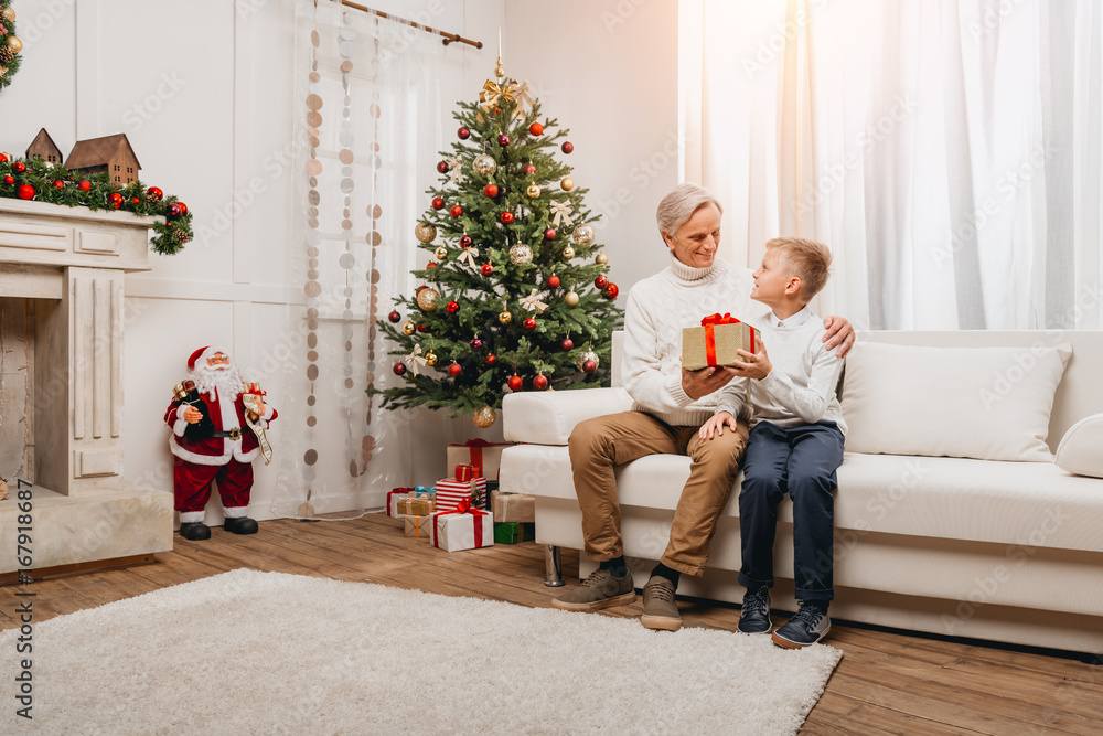 grandfather presenting christmas gift to grandson