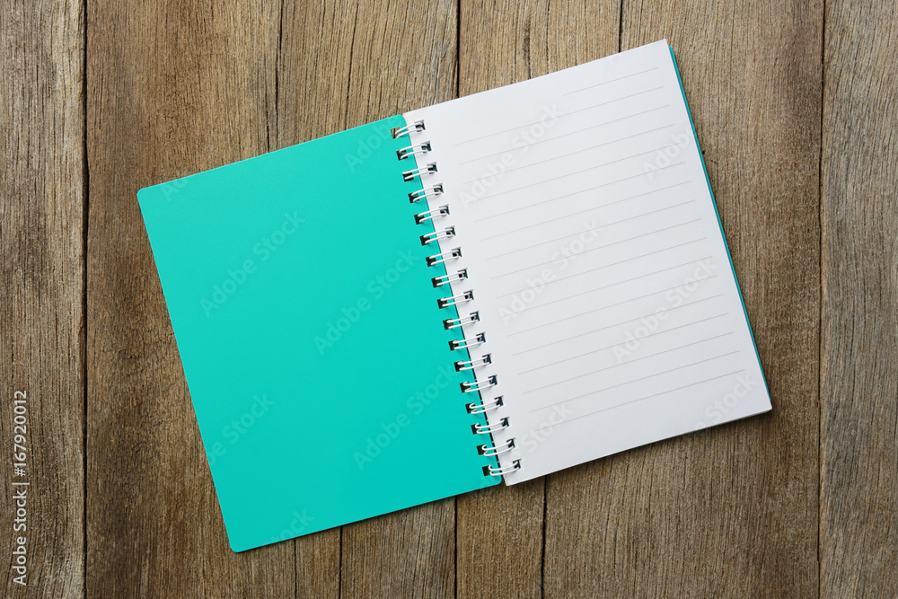 notepad book is placed on a brown wooden floor. notepad book is placed on a brown wooden floor.