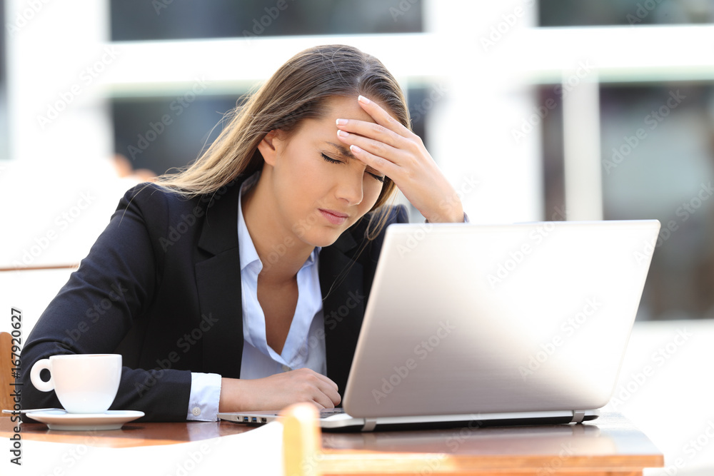 Businesswoman suffering head ache in a coffee shop Businesswoman suffering head ache in a coffee shop