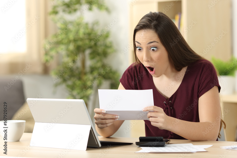 Amazed woman reading good news in a letter Amazed woman reading good news in a letter