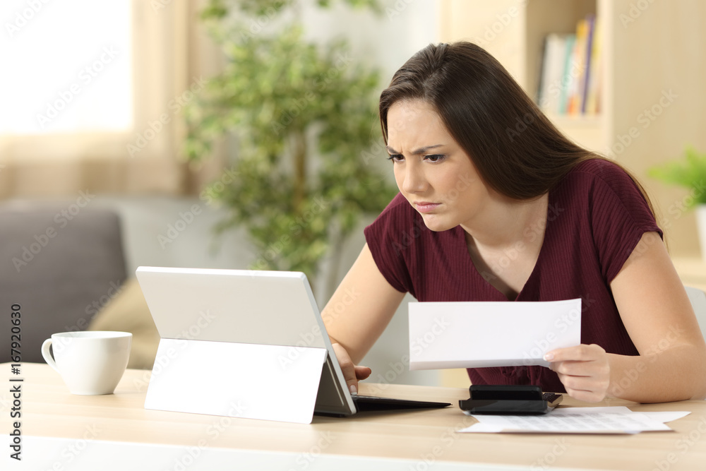Confused woman comparing on line information Confused woman comparing on line information