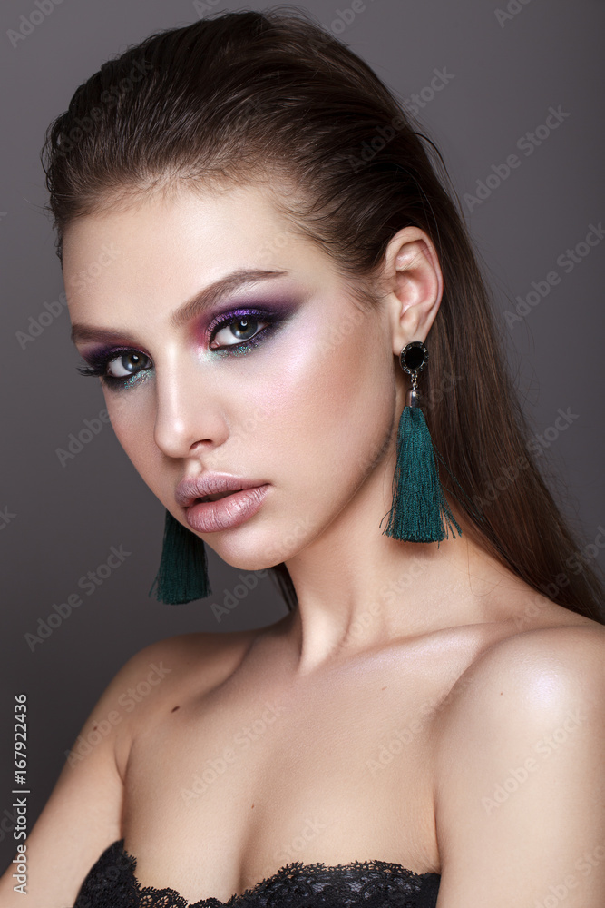 Beautiful young model with fashion make up, perfect skin, long earrings and wet hair. Trendy colorful smoky eyes. Beautiful young model with fashion make up, perfect skin, long earrings and wet hair. Trendy colorful smoky eyes.
