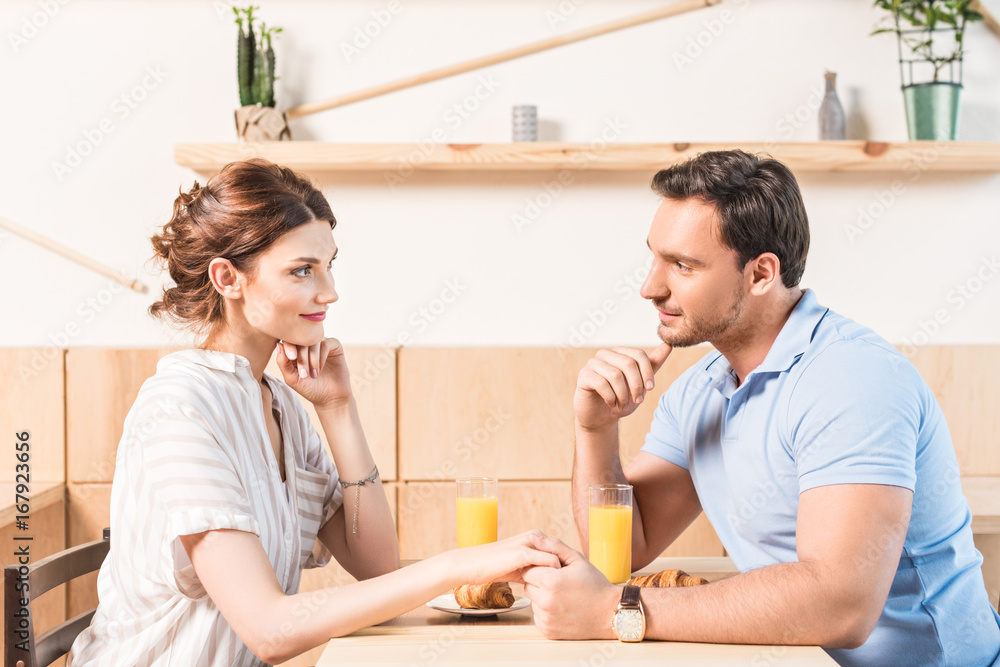 young couple dating and holding hands in cafe young couple dating and holding hands in cafe