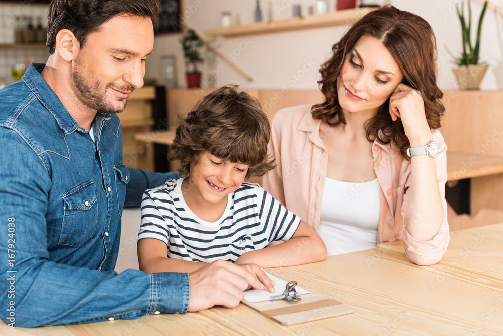 beautiful young family in cafe looking at paycheck