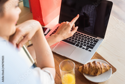 young woman making e-shopping in cafe