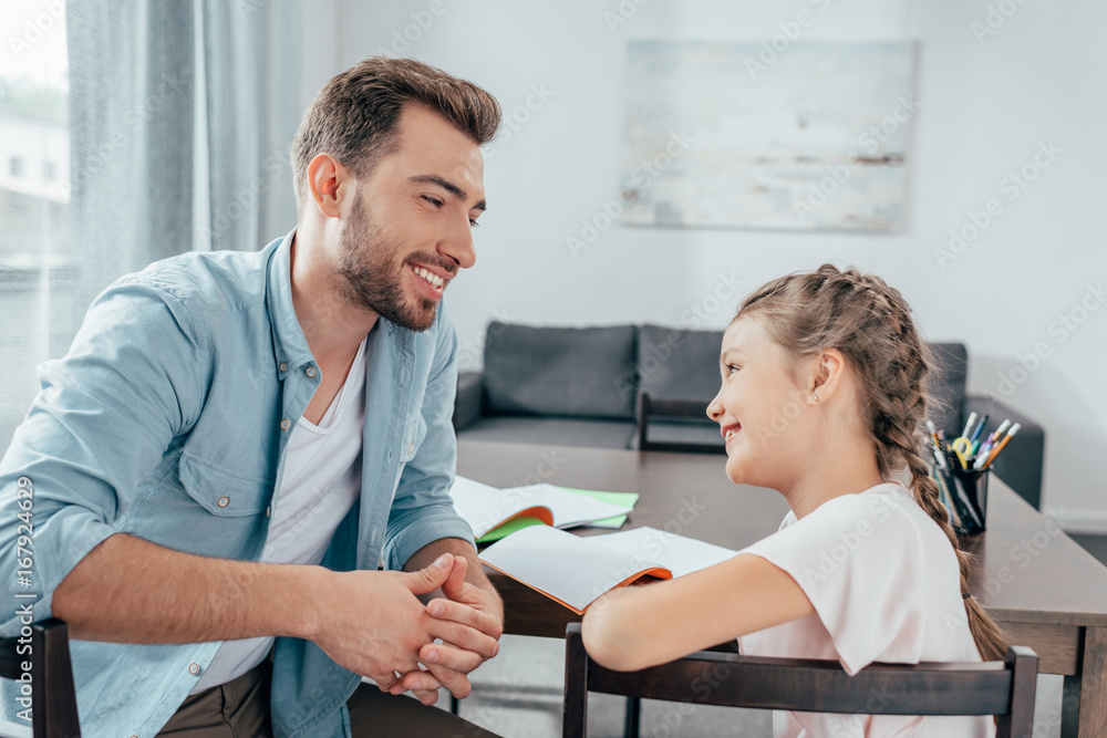 young father doing homework with little daughter young father doing homework with little daughter