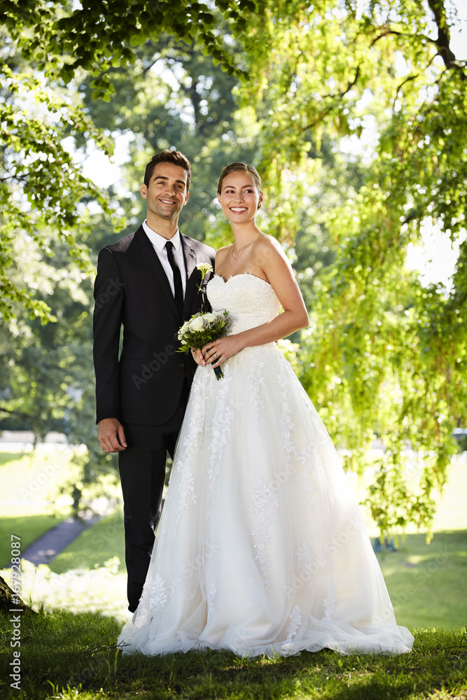 Newly wedded glamorous couple smiling outdoors