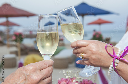 Wedding couple holding pair of champagne glasses
