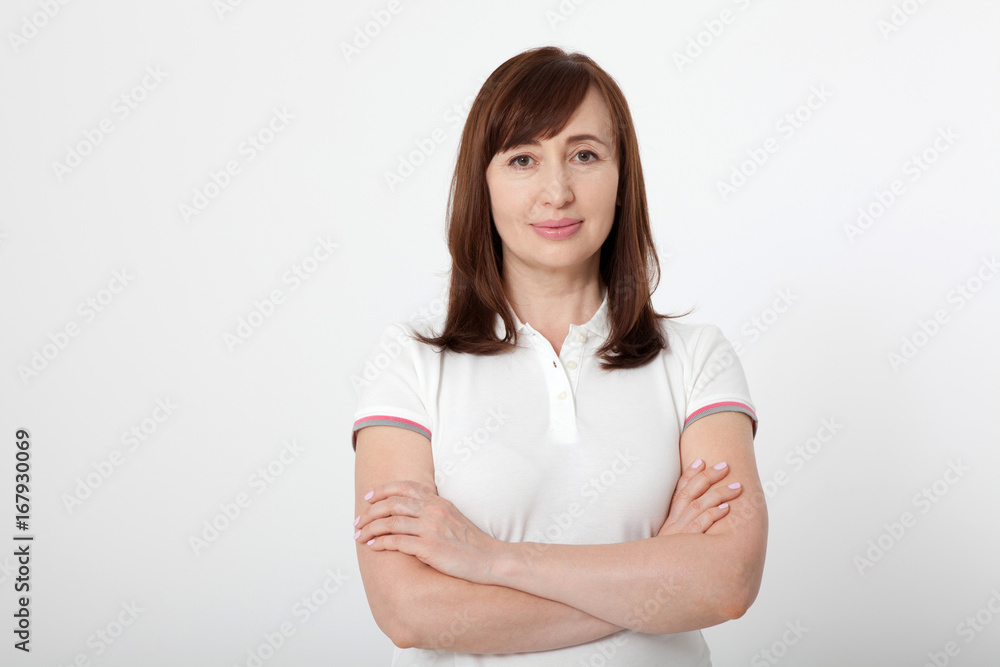 Portrait of serious woman in blank white t-shirt and crossed arms on chest with copy space on white background. Mock up Portrait of serious woman in blank white t-shirt and crossed arms on chest with copy space on white background. Mock up